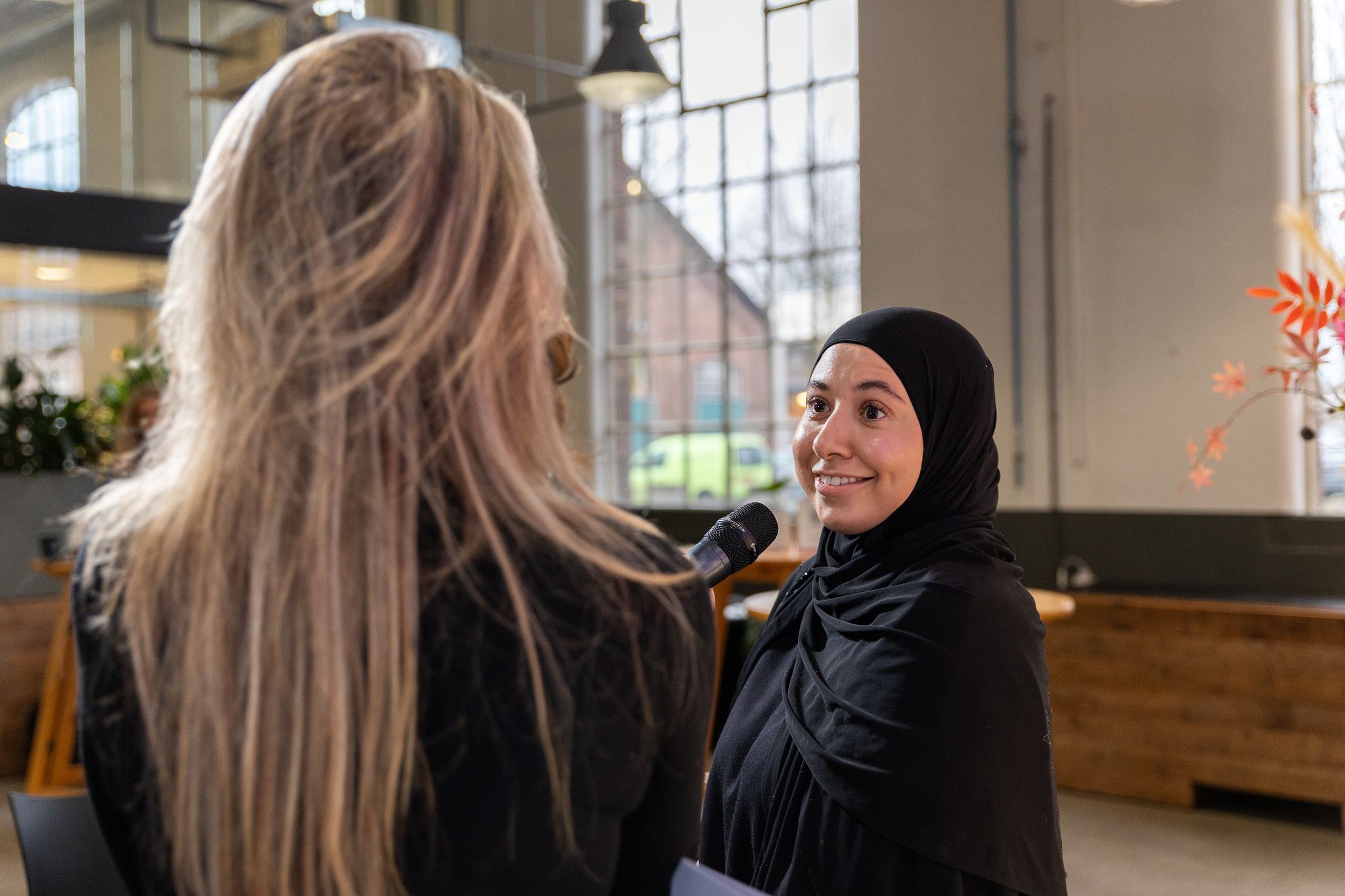 De gastvrouw van het Evenementen Bewustwording inclusief ondernemerschap praat met een deelneemster.